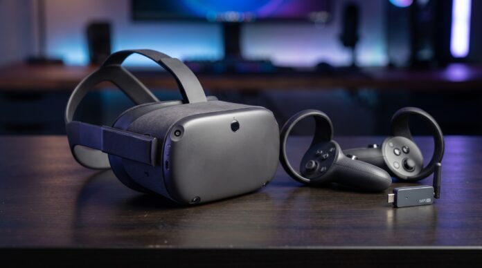Visor de realidad virtual con dos controles inalámbricos y un adaptador WiFi sobre un escritorio